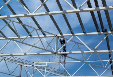 Endüstriyel inşaat alanı, inşaat mesleği geçmişi. Kopya alanı olan yüksek katlı metal çerçeve. İnşaat ve emniyet kemeri. Mühendislik ve inşaat endüstrisi kavramı