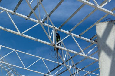 Endüstriyel inşaat alanı, inşaat mesleği geçmişi. Kopya alanı olan yüksek katlı metal çerçeve. İnşaat ve emniyet kemeri. Mühendislik ve inşaat endüstrisi kavramı