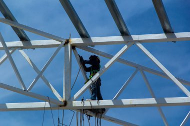 Endüstriyel inşaat alanı, inşaat mesleği geçmişi. Kopya alanı olan yüksek katlı metal çerçeve. İnşaat ve emniyet kemeri. Mühendislik ve inşaat endüstrisi kavramı