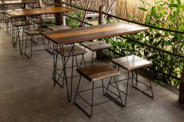 Pirinç teraslarının yanındaki boş tropikal kafede tahta masa ve sandalyeler.