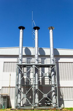 Kazan dairesinin boruları mavi gökyüzüne karşı. Soyut sanayi geçmişi.