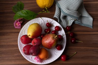 Taze armut kayısı, tatlı kiraz ve ahşap masada limon.. 