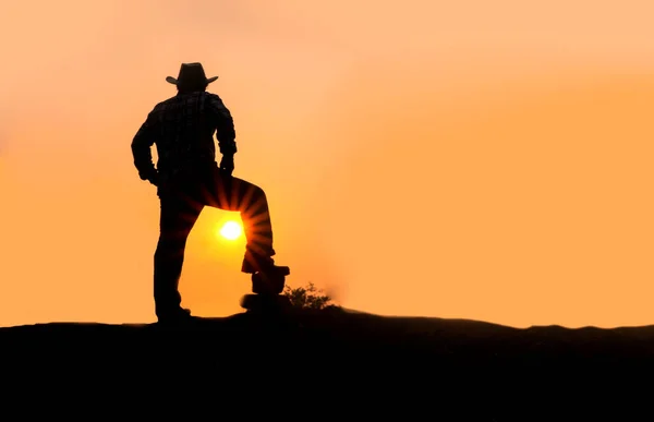 stock image The shadow of a man wearing a cowboy hat stands on the sunshine in the countryside in Thailand.