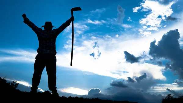 stock image Thai people stand holding hoes with both arms raised, back view looking at the mountains at sunset at night, black silhouette, man alone