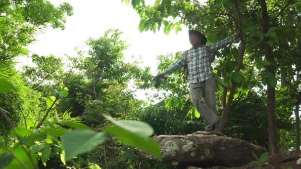 大人の男性観光客 バックパック スタンド ロック 休暇で写真を撮ります ポイントを見る 山の森で タイの国立公園でのソロアドベンチャー旅行 — ストック動画