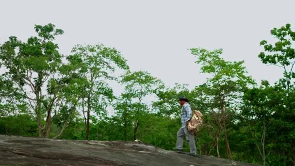 男性の観光客バックパッカーは 岩の上に座って写真を撮ります 休暇旅行 山の森の景色ポイント タイで最高の国立公園でのソロアドベンチャー旅行 — ストック動画