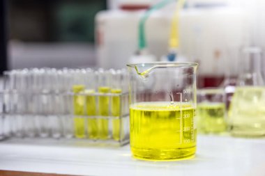 Bir emülziyoncunun soluk sarı çözeltisi laboratuvar ya da endüstrideki kozmetik ürününün formülasyon testi için bir beher. Kozmetiğin Araştırma ve Geliştirilmesi.