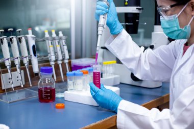 Bilimadamları, laboratuardaki tüp numune stok çözeltisinden alınan numune hazırlamak için tüp ile tüp içinde tüp biyoanaliz yapan bir mikro pipet kullanıyorlar. Tıp, Tıp ve Biyokimya araştırmaları.