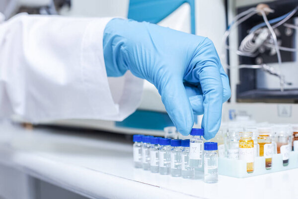 A hand of scientists arrange vials of samples in order of sample or prepare samples for analysis by Liquid Chromatography mass spectrometry LC-MS analysis in the lab. LC-MS is used for scientific research.