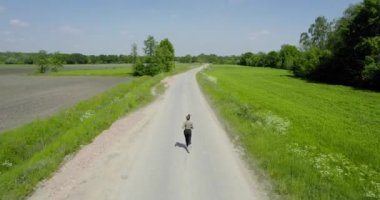 Sport woman running outdoor. woman jogging in rural area between the fields, aerial view. Back view of running people active training in park. fitness runner jogging outdoor. Sport people running in