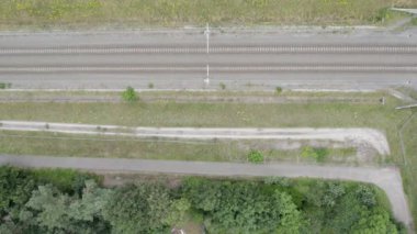 Kırsal kesimde tren yolu köprünün altından geçiyor, hava manzarası - güzel yeşil manzara - seyahat, doğa ve ulaşım kavramları. Yüksek kalite 4k görüntü