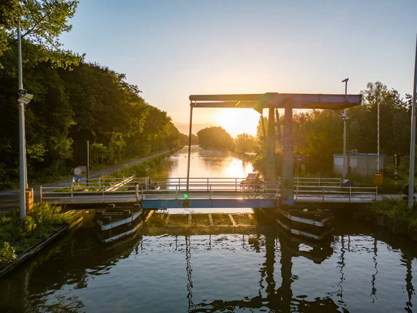 stock image Aerial view of a colorful dramatic sunrise sky over a canal with a draw bridge in Belgium. Canals with water for transport, agriculture. Fields and meadows. Landscape. High quality photo