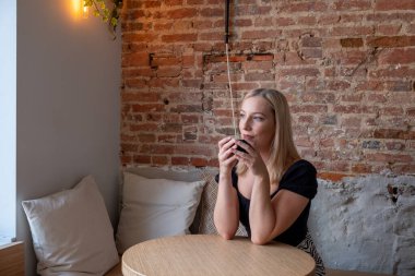 Modern kafe barında bir fincan kahveyle oturan güzel beyaz bir kadın yeni fikirleri düşünen çekici bir kadın. Yüksek kalite fotoğraf