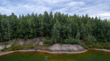 Blue lakes from above. Lakes in green forest in evening sunlight aerial drone view. Scenic summer background. Picturesque lakeside with forest. High quality photo. High quality photo