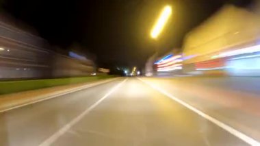 Hızlı sürüşün inanılmaz bir hareket zamanı. Bir sürü ışık ve yol boyunca evlerin önünden geçen hızlı bir araba. Yüksek kalite 4k görüntü