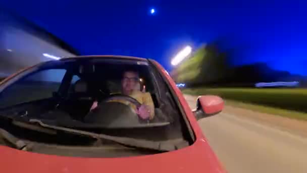开放道路的自由 坐在前排的是快乐的中年男人 他们在晚上开车 晚上高兴地微笑着 在车后留下了轻盈的痕迹 — 图库视频影像