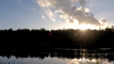 Gün doğumunda Güzel Orman Gölü 'nün Pan Manzarası ya da Suyun Üzerinde Renkli ve Dramatik Gökyüzünün Yansımasıyla Gün Batımı. Yüksek kalite 4k görüntü