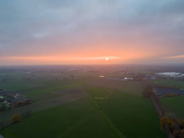 stock image Aerial view of endless lush pastures and farmlands of Belgium under a dramatic colorful sunset sky. Beautiful antwerp countryside with emerald green fields and meadows. Rural landscape on sunset. High