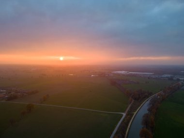 Yeşil çalıları ve renkli gökyüzü olan bir nehrin üzerinde güzel bir günbatımı. Yüksek kalite fotoğraf