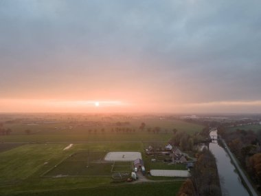 Yeşil çalıları ve renkli gökyüzü olan bir nehrin üzerinde güzel bir günbatımı. Yüksek kalite fotoğraf