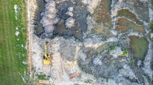 Sarı, buldozerin toprak çalışmasını, havadan görüntü çekimini izledi. Sarı renkli traktör asfalt yol yapmak için zemini tırmıklıyor. Toprak buldozer yol inşaatı sırasında çalışır.