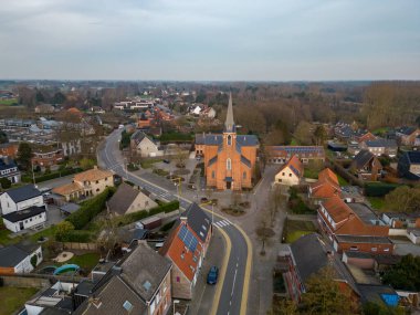 Emblem, Ranst, Belgium, 15th of February, 2023, Sint-Gummaruskerk, church of saint Gummarus, in the voortstraat of the Little village of Emblem, in the Antwerp area aerial photo during morning sunrise