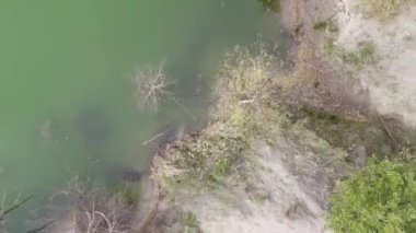 Turquoise water in a mountain forest lake with pine trees. Aerial view of blue lake and green forests. View on the lake between mountain forest. Fresh water . High quality 4k footage