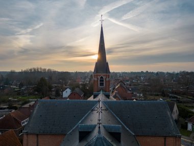 Emblem, Ranst, Belgium, 15th of February, 2023, Sint-Gummaruskerk, church of saint Gummarus, in the voortstraat of the Little village of Emblem, in the Antwerp area aerial photo during morning sunrise