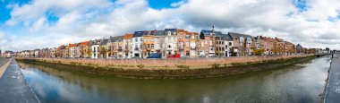 Mechelen, Antwerp, Belçika, 16 Kasım 2022, Mechelen, Belçika 'da Dijle nehrinin kıyısında tarihi binalar bulunan ve ön planda su bulunan bir caddenin panoramik görüntüsü.