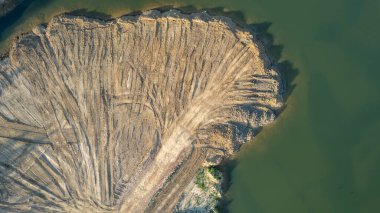 Aerial drone photo of Quarry turquoise green lake colour and the pathways of the equipment and excavators, open pit clay mining in Belgium. High quality photo