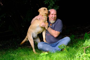Yakışıklı Adam Arka Bahçe Bahçesinde Mutlu Altın Labrador Köpeği ile oynuyor. Sadık Pedigree Dog 'la Sadık Ev Bahçesi' nde Eğlenen Adam. Yüksek kalite fotoğraf