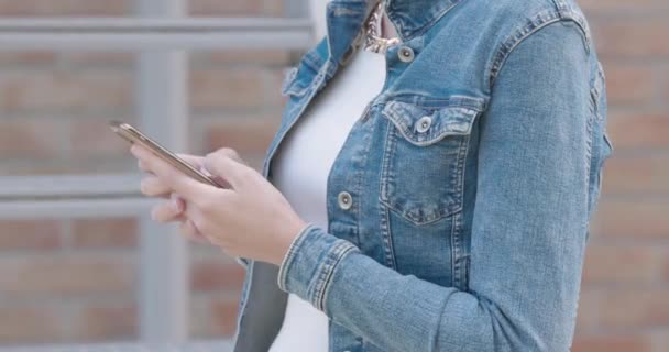 Młoda Biała Kobieta Modnym Stroju Niebieskiej Kurtce Dżinsów Używa Smartfona — Wideo stockowe