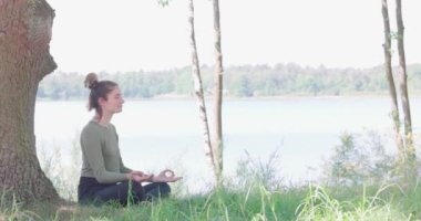 Kadın meditasyonu, zen yoga meditasyonu. Yogi kızı nilüfer çiçeği pozunda oturuyor, sağlıklı yaşam tarzı, meditasyon konsepti. Yüksek kalite 4k görüntü