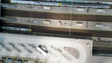 Tren istasyonu ulaşım merkezinin yukarıdan çekilmiş görüntüleri farklı trenlerin yan yana, platformların yanında ve dışarıda bekleyen otobüsleri gösteriyor. Yüksek kalite 4k