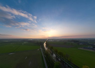 Güneşli bir günde tarıma kuşların bakış açısı ve yeşil dalgalı tarlalar. Tarım endüstrisi. Belçika 'nın tarım bölgesi, Avrupa. Sinematik hava çekimi. Toprağın güzelliği. Yüksek kalite fotoğraf