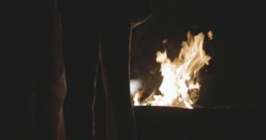 Yakın plan, ateşten alevler. Gece ateşi, odunlar yanıyor, kıvılcımlar uçuşuyor. Yüksek kalite 4k görüntü