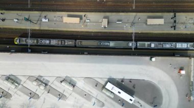 Tren istasyonu ulaşım merkezinin yukarıdan çekilmiş görüntüleri farklı trenlerin yan yana, platformların yanında ve dışarıda bekleyen otobüsleri gösteriyor. Yüksek kalite 4k
