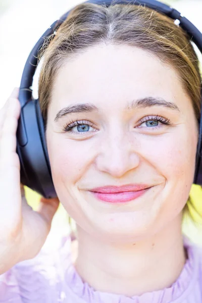 女人们带着耳机 近距离听着音乐 在户外享受着自由和科技的快乐 调音空间 播客或广播流媒体 绿色背景中的女性和音频播放列表 — 图库照片