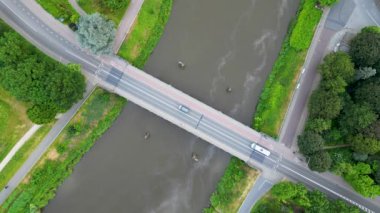 Tranquil River Crossing: Sahne Köprüsü ve akan sularla Hava Huzuru. Yüksek kaliteli 4K görüntüler, kendinizi bir an sükunetin içine daldırın bir köprünün büyüleyici hava görüntüsüne tanıklık ederken