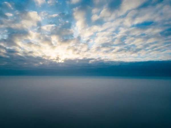 印象的な航空写真は 雲の豪華な毛布の上に昇る太陽の見事な光景を捉えます 永遠のイメージは 圧倒的な平和感 広大さ 雄大さを想起させます — ストック写真