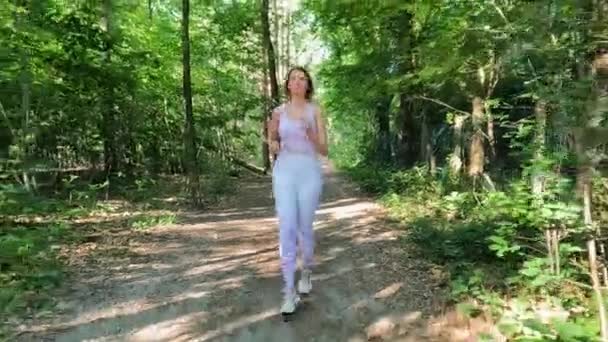 加入一个年轻而坚定的健身爱好者的行列 她开始在茂密的绿林中奔跑 让人神清气爽 这段充满活力的视频展示了她对健康生活的承诺 — 图库视频影像