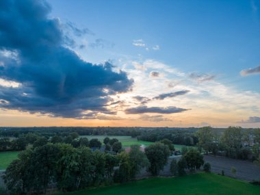 Doğanın dramatik, bulutlarla dolu gökyüzünün altında beliren nefes kesen manzarasına bakın. Bu büyüleyici hava manzarası, yemyeşil çayırlarla süslenmiş el değmemiş doğal bir manzarayı gözler önüne seriyor.