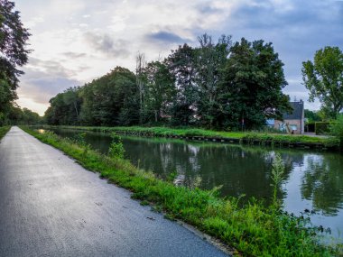 Doğanın sükunetini bu büyüleyici alçak açılı manzarayla kucaklayın görkemli yüksek ağaçların arasında zarafetle kıvrılan görkemli bir kanal görüntüsünü yakalayın. Rahatlatıcı bir şekilde