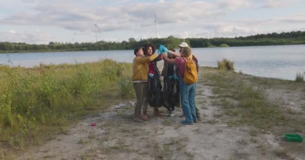 英俊勤劳的多种族男女千禧年来与他们的朋友 自然活跃分子一起 帮助把垃圾收集到塑料袋里 并互相帮助 社会反对污染 — 图库视频影像