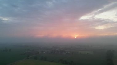 Gökyüzü manzaralı romantik pembe gökyüzü kırsal ve ağaçlı doğal bir kırsal bölge üzerinde. Soyut arka plan. Parlak kırmızı ışık ışınları ve diğer atmosfer etkileriyle gün doğumu.