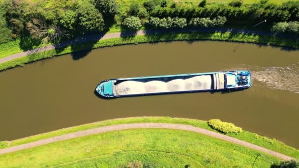 从上面拍摄的镜头揭示了一艘货船 它在蜿蜒的河流中平稳航行 不过是巨大帆布上的一个斑点 绿树成荫 草木成画 — 图库视频影像