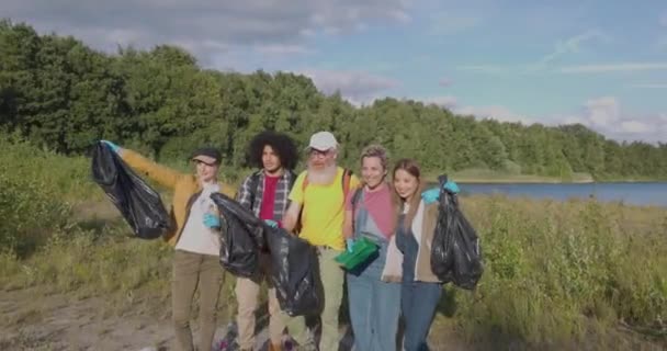 在这个令人振奋的镜头中 一群千百年来的朋友正在准备清理森林湖岸 他们装着垃圾袋 随时准备恢复自然美 Natures — 图库视频影像