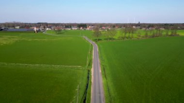 Havadan çekilen görüntüler, yemyeşil ve yemyeşil bir araziyi kesen yalnız bir yolu gösteriyor. Yol, gri şeritten bir şerit görevi görüyor.