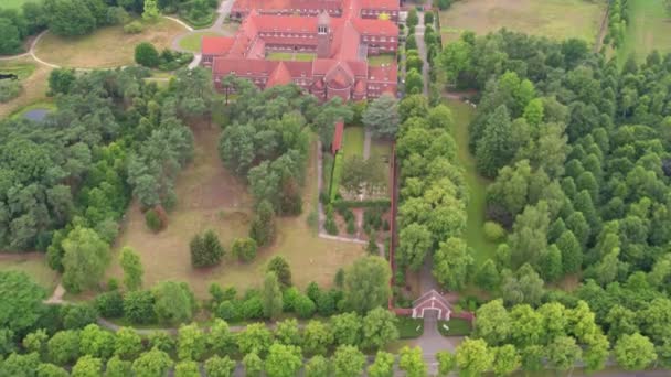 俯瞰的镜头展示了位于比利时布莱希特的拿撒勒夫人修道院的空中景观 该修道院坐落在茂密的绿地中 宏伟的红顶建筑散发出一种历史气息 — 图库视频影像
