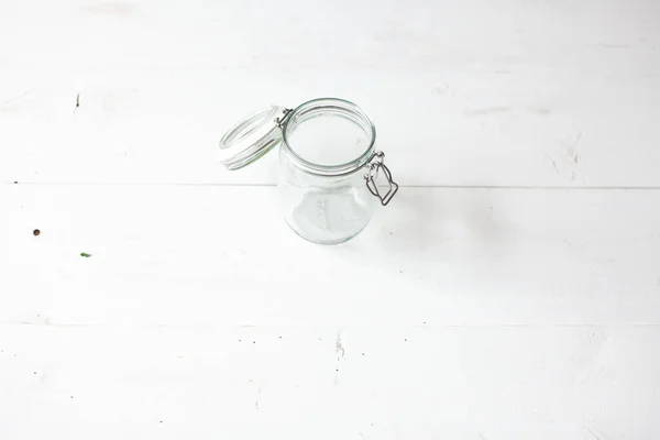 The image presents a single, open glass jar on a pristine white background, capturing the essence of minimalist design. The jars transparency and simplicity stand out, offering both functionality and